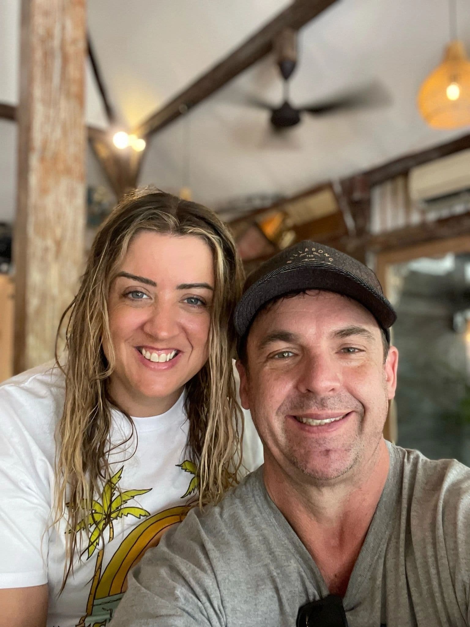 Gary and Cindy smiling in a tropical open-air restaurant