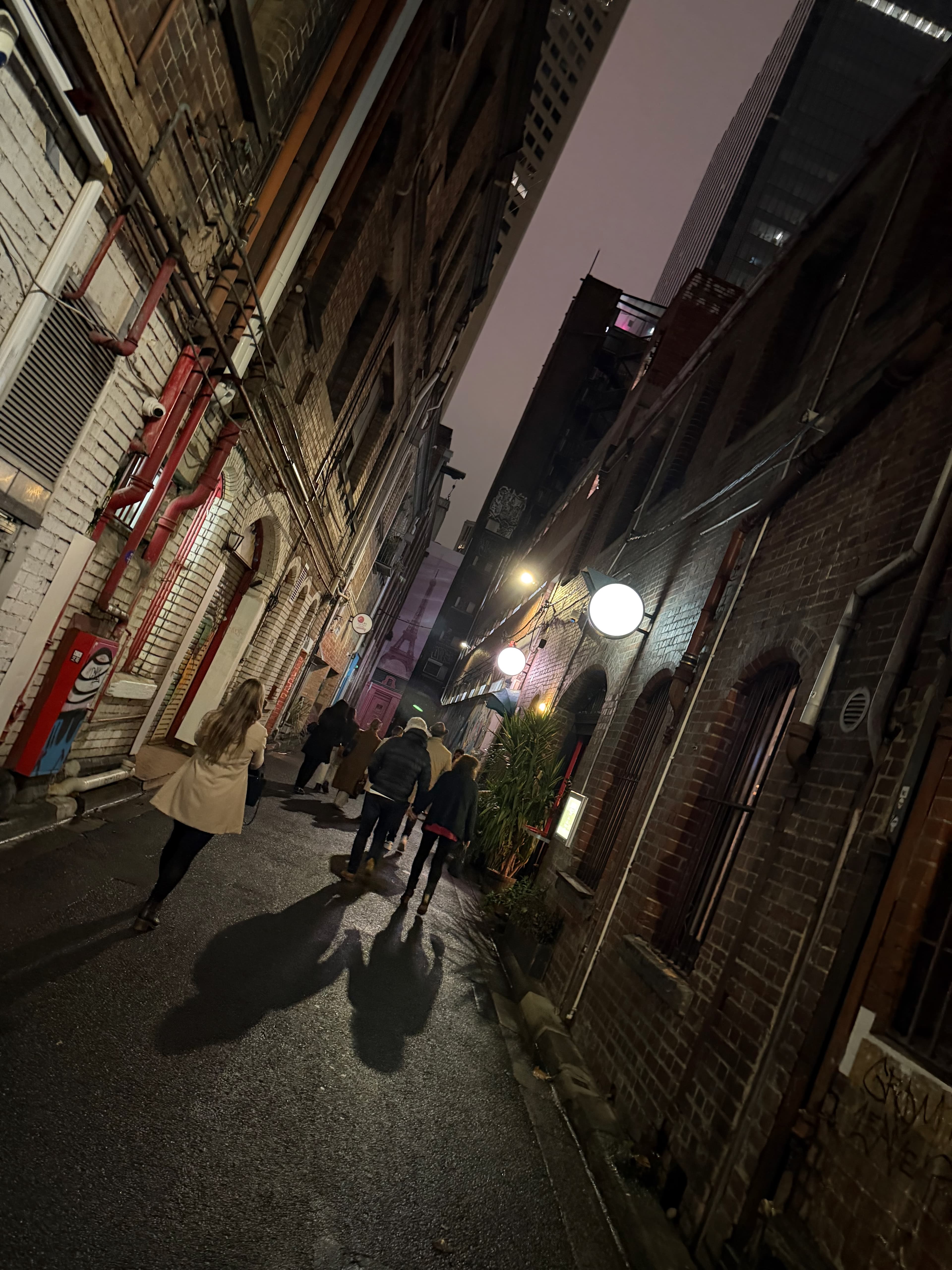 Melbourne laneway at night with glowing globe lights